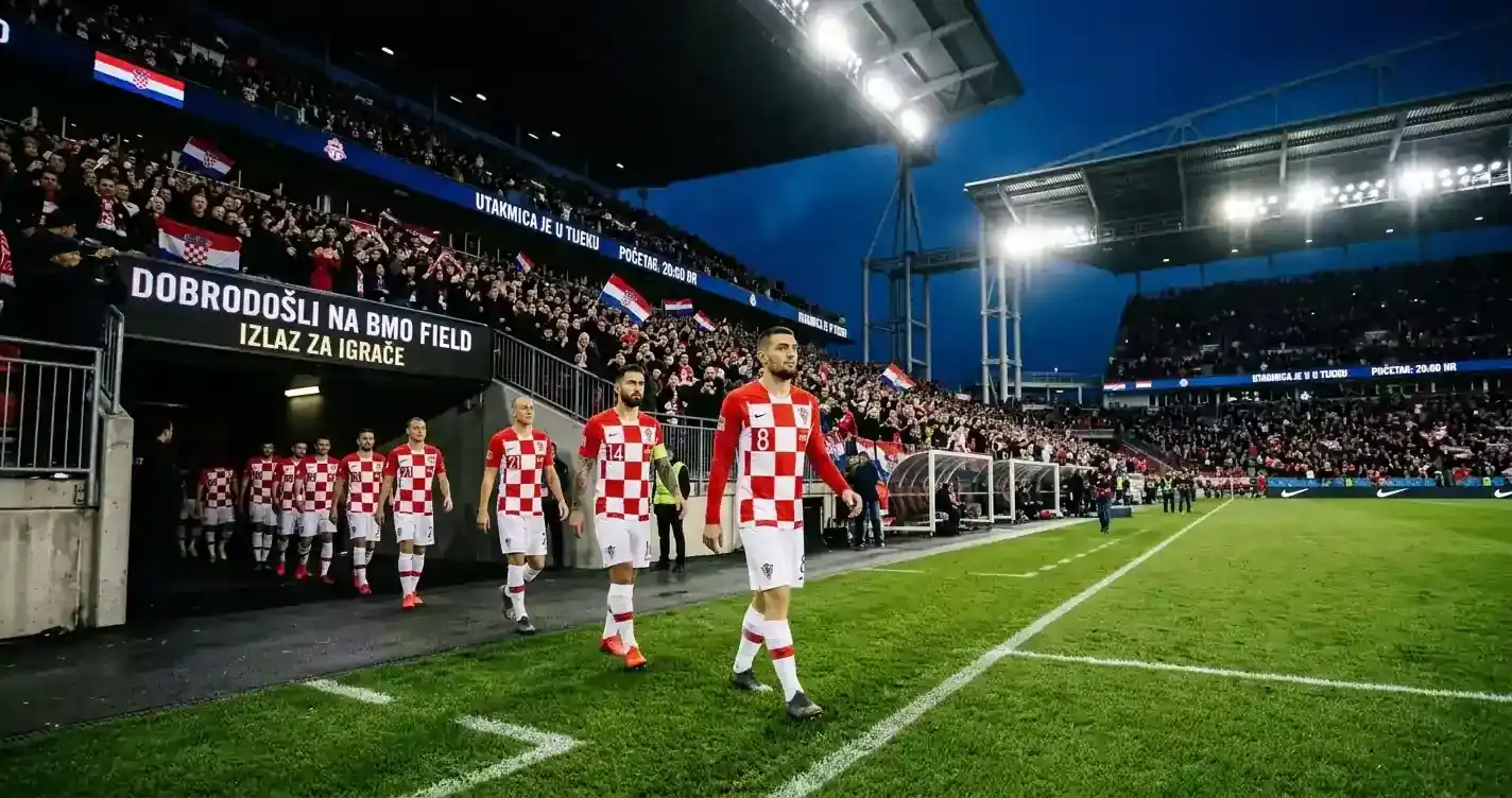 Hrvatski nogometaši u crveno-bijelim dresovima izlaze iz tunela na osvijetljeni stadion BMO Field u Torontu prije utakmice protiv Paname